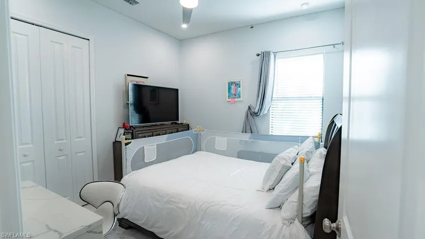 Bedroom featuring a window with blinds, bi-fold closet doors, recessed lighting, and a ceiling fan