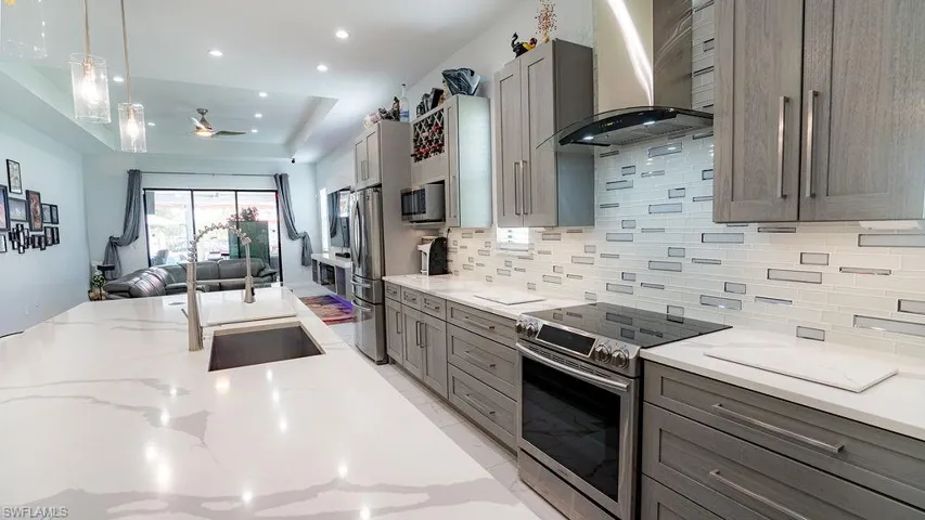 Contemporary kitchen featuring an expansive island with an undermount sink and two pendant lights