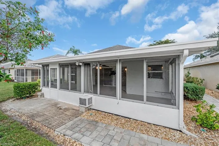 Back of property featuring a sunroom & paver patio & walkway.