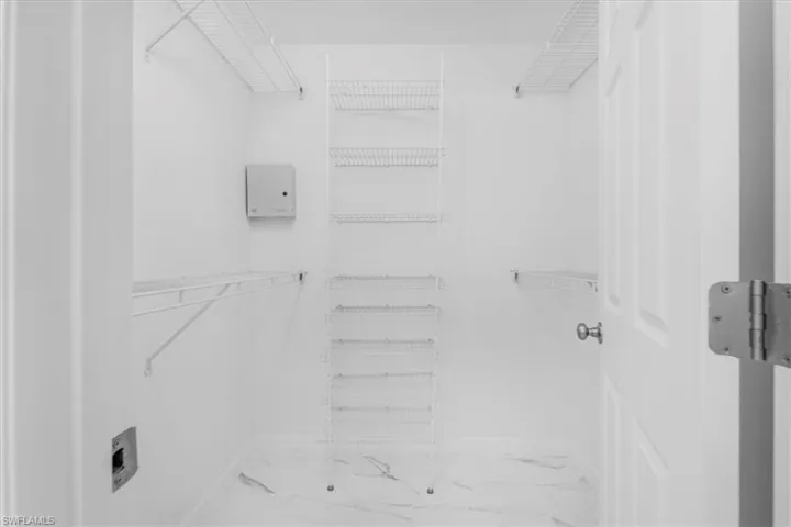 Main bedroom Walk in closet featuring new tile floors