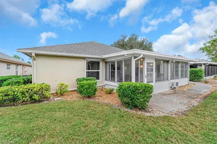 Rear view of house featuring a sunroom, new roof 2020, & patio area