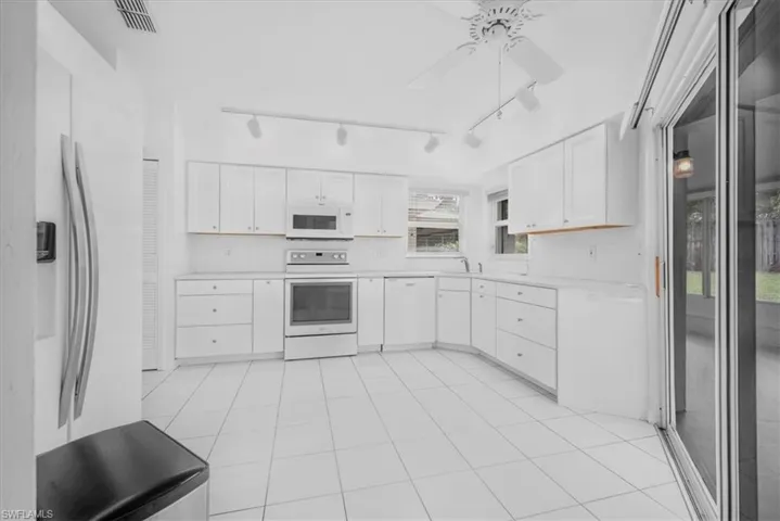 Updated kitchen cabinets with quartz tops, track lighting & sliders out to large lanai with A/C.