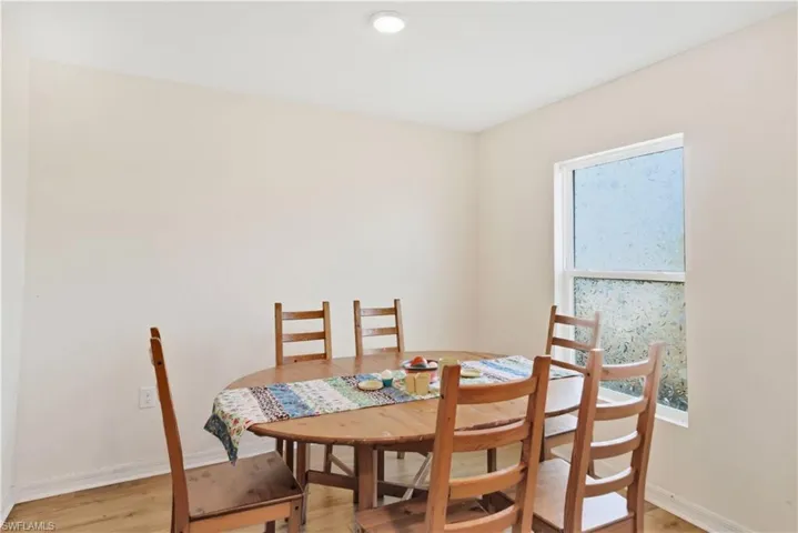 Dining room with light wood-type flooring and baseboards