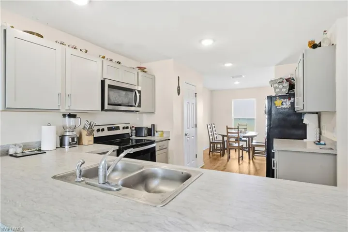 Kitchen featuring light countertops, appliances with stainless steel finishes, gray cabinets, light wood-style floors, and recessed lighting