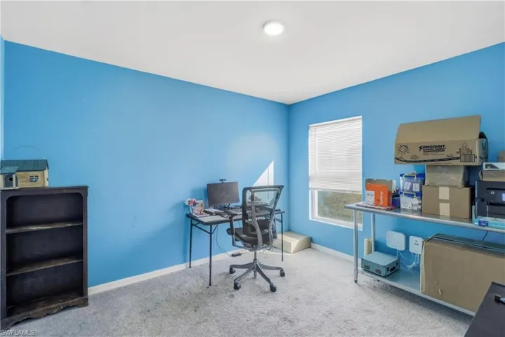 Office space with baseboards and carpet flooring