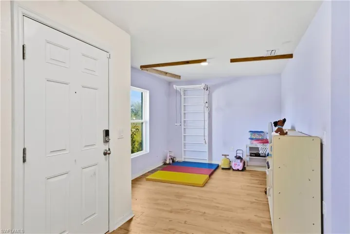 Foyer entrance with light wood-style flooring and baseboards
