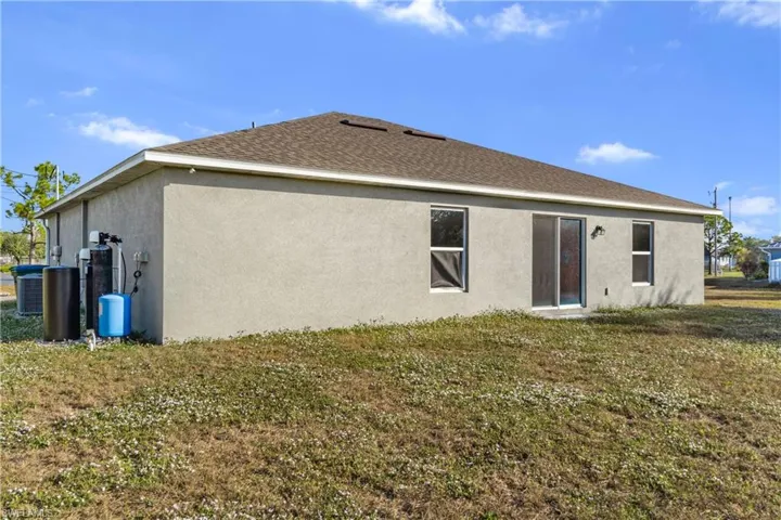 Rear view of house with a yard and stucco siding
