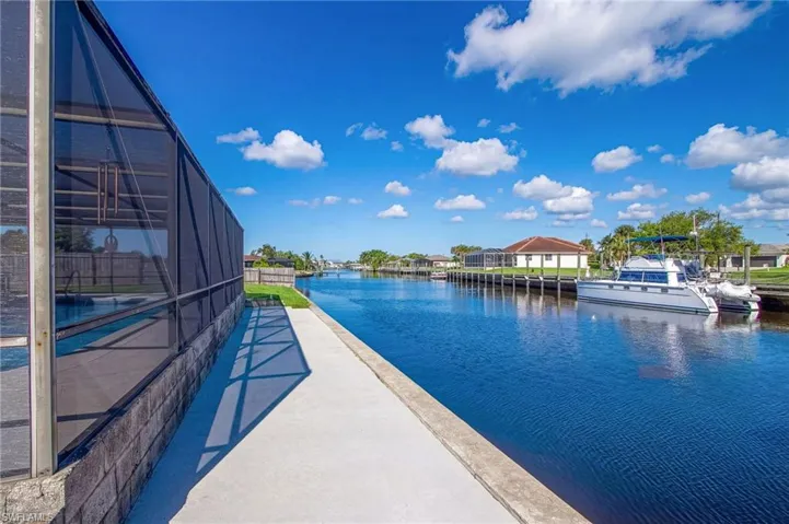 View of pool with an infinity pool, a water view, and a sunroom