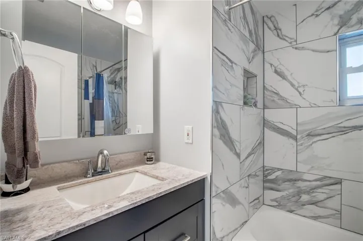 Bathroom featuring vanity and shower / tub combo with curtain