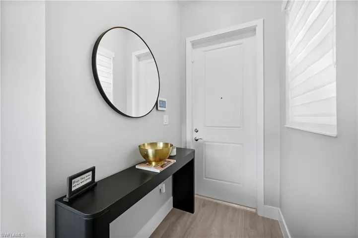 Doorway to outside with light wood-style floors and baseboards