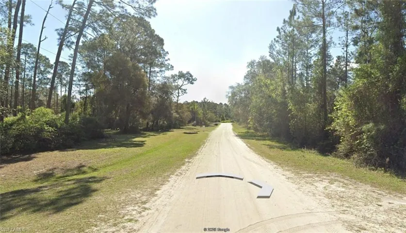 View of dirt / gravel road featuring a view of trees