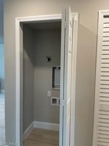 Washroom with wood-type flooring and hookup for an electric dryer