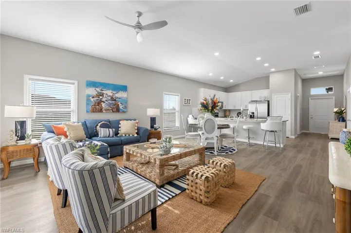 Living room with plenty of natural light, ceiling fan, and light wood-type flooring