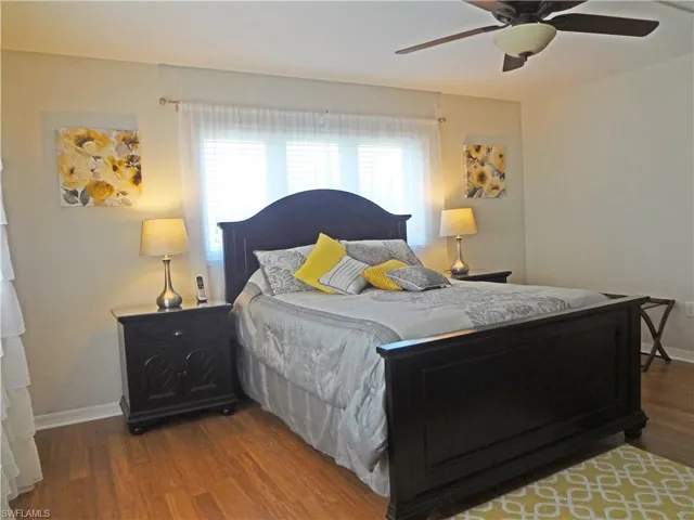 Bedroom with dark wood-type flooring and ceiling fan