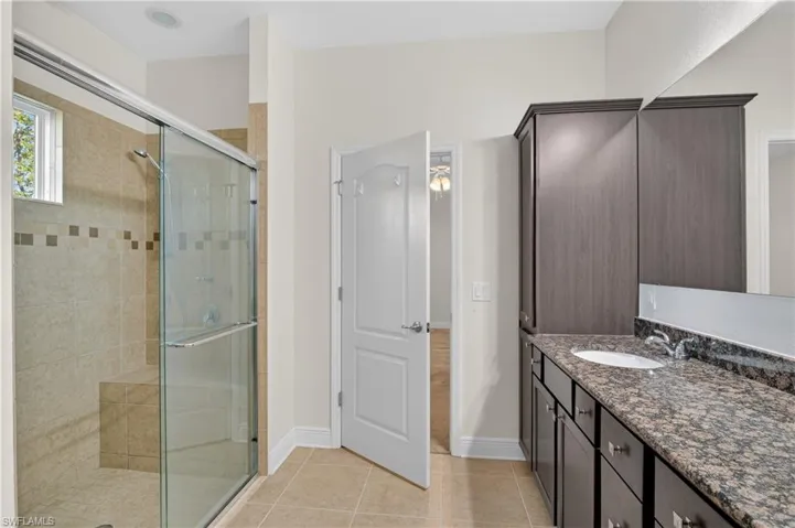 Primary bathroom has a luxury shower with built in seating and three showerheads