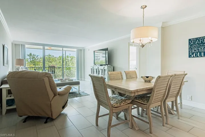 Dining space featuring crown molding, a chandelier, and floor to ceiling windows
