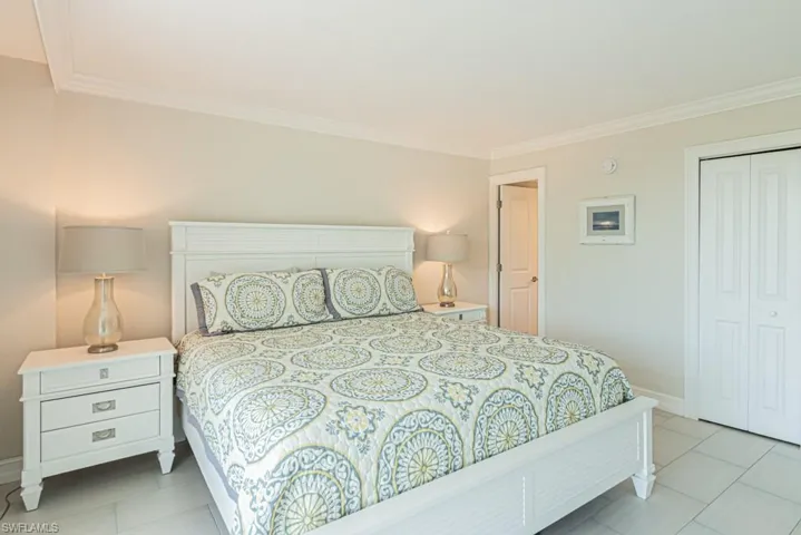 Bedroom featuring ornamental molding, baseboards, a closet, and tile patterned flooring