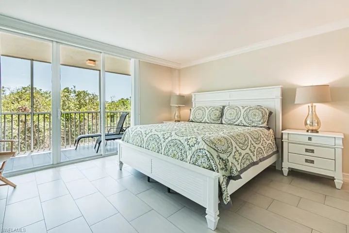 Bedroom featuring access to exterior and crown molding