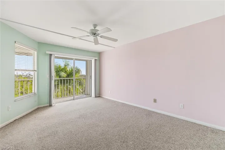 Empty room featuring carpet flooring and a ceiling fan