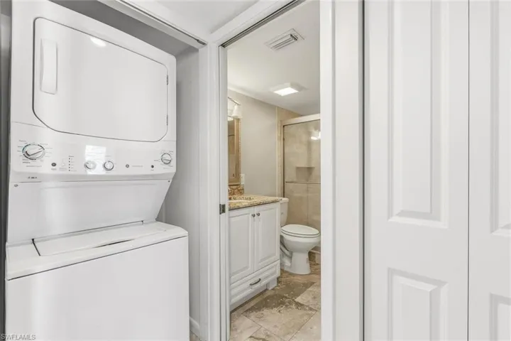 Full bath with a shower stall, vanity, ajavascript:__doPostBack('m_lbSave','')nd stacked washing machine and dryer