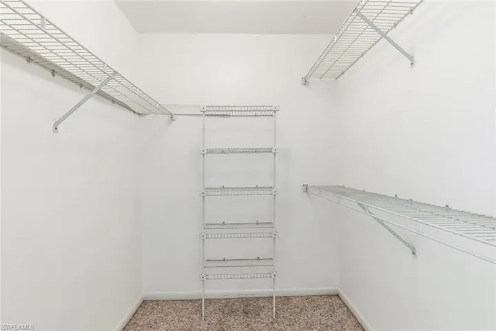 Walk in closet featuring light carpet