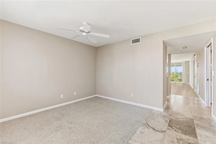 Unfurnished room featuring light colored carpet and a ceiling fan