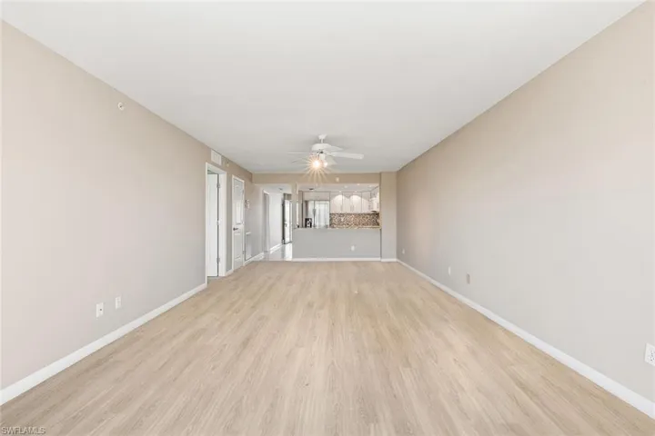 Unfurnished living room featuring light wood-style floors and a ceiling fan