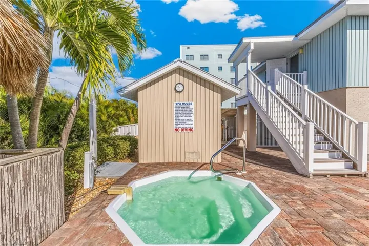 View of swimming pool featuring stairs, a patio area, a community hot tub, and a balcony