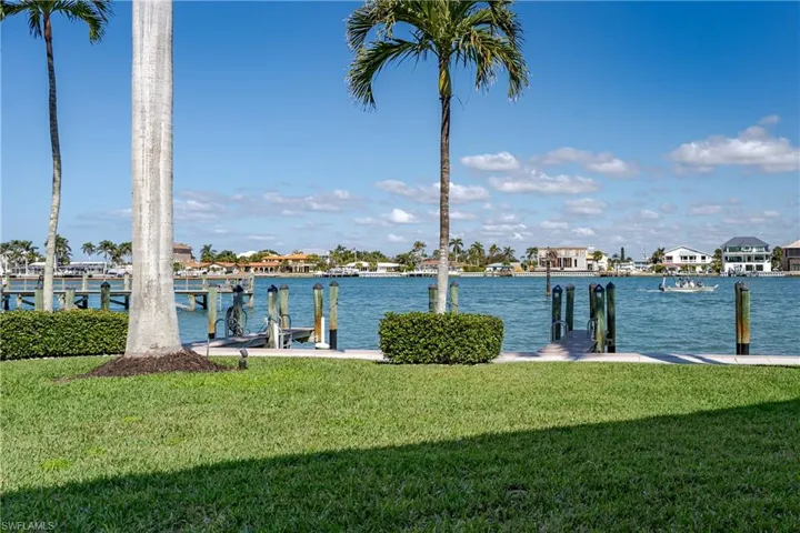 Dock area featuring a water view and a lawn