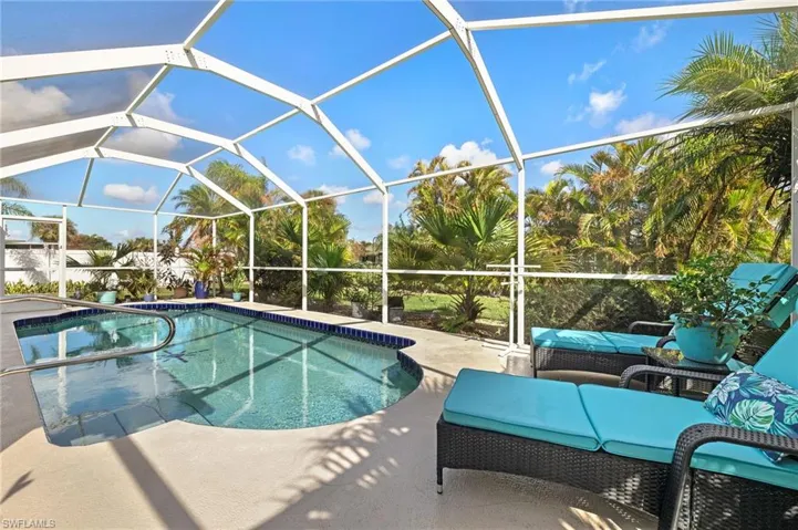 View of pool with a patio and glass enclosure