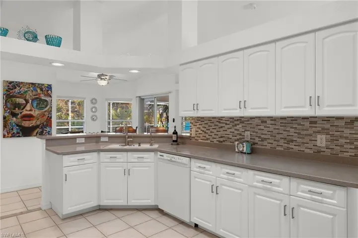 Kitchen with white cabinetry, dishwasher, and kitchen peninsula
