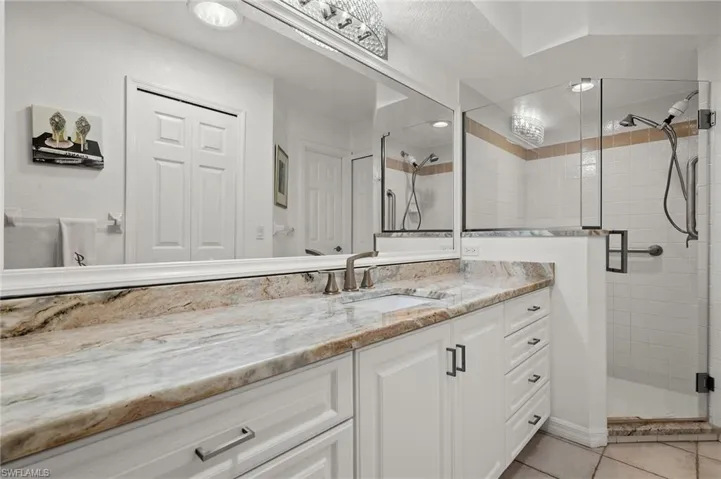 Bathroom featuring vanity, tile patterned flooring, and an enclosed shower