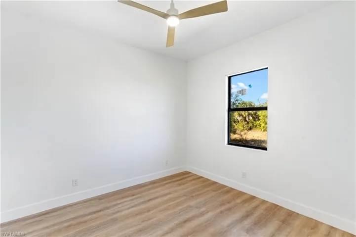 Empty room featuring light wood-style floors and a ceiling fan
