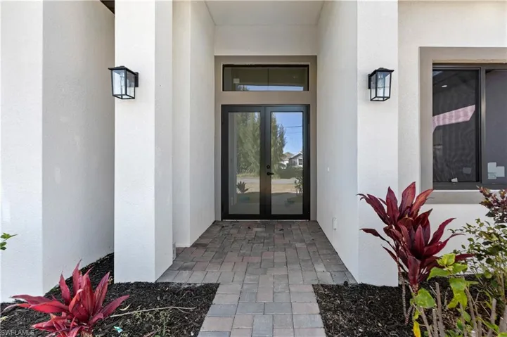 View of exterior entry with french doors and stucco siding