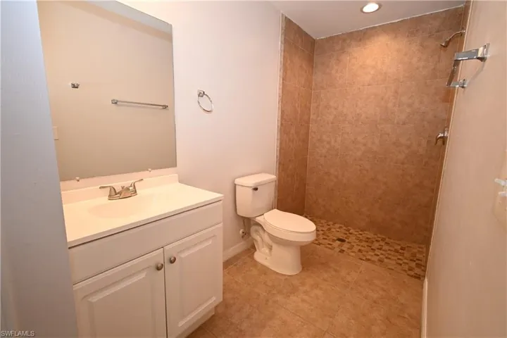 Bathroom featuring a walk-in shower with mosaic tile flooring and full-height wall tiling