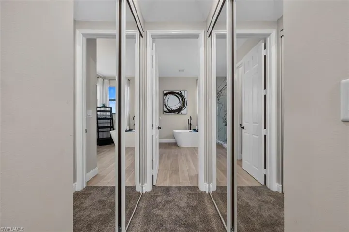 Hallway featuring mirrored sliding closet doors