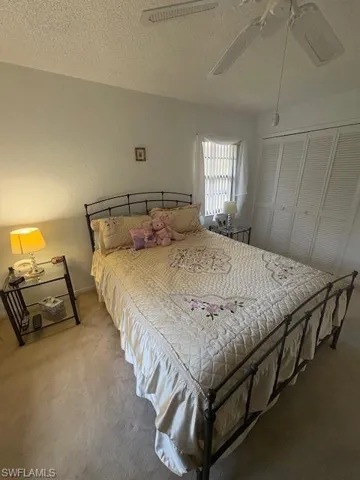 Carpeted bedroom featuring , two closets, and ceiling fan