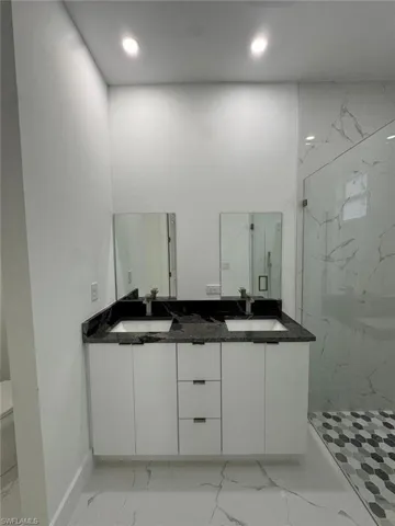 Bathroom featuring a shower with door and vanity
