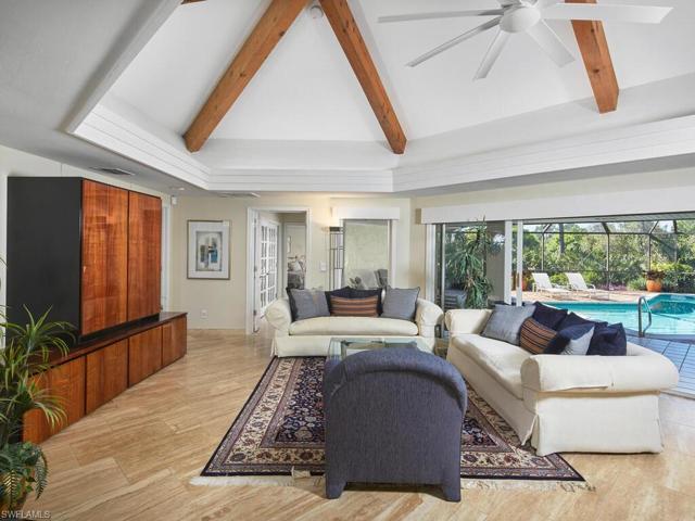 This home, located in the esteemed Woodlake community, is surrounded by lush, tropical foliage.