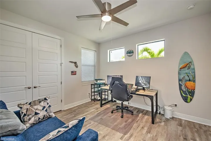 Home office featuring a wealth of natural light, ceiling fan, and light wood-type flooring