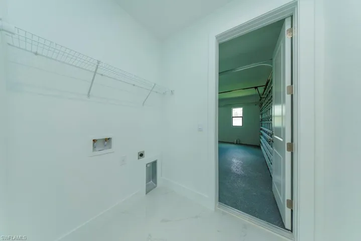 Utility room featuring white wire shelving and a washer/dryer hookup