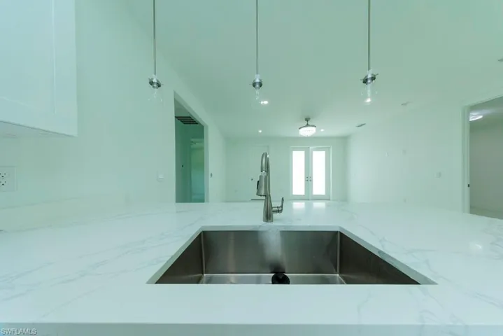 Waterfall edge countertop with integrated stainless steel sink and a single-handle faucet