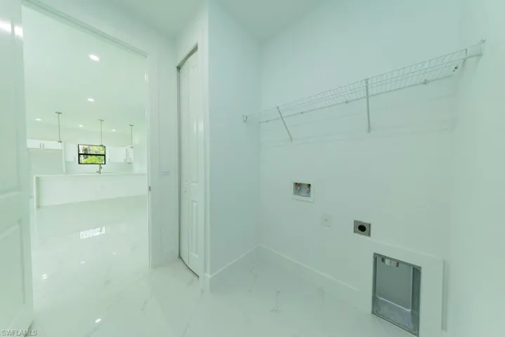 Dedicated laundry space featuring white walls and tile flooring