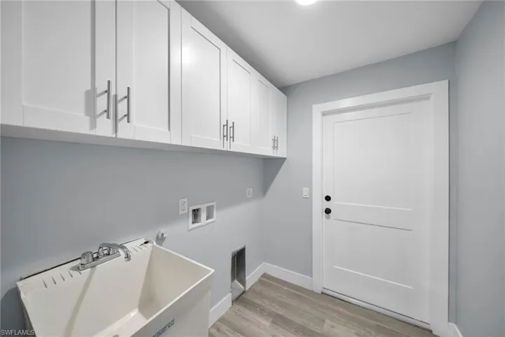 Laundry room featuring light wood-style flooring, hookup for a washing machine, and cabinet space