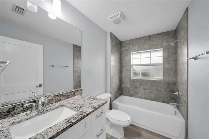 Full bathroom featuring bathtub / shower combination, vanity, and light wood-type flooring