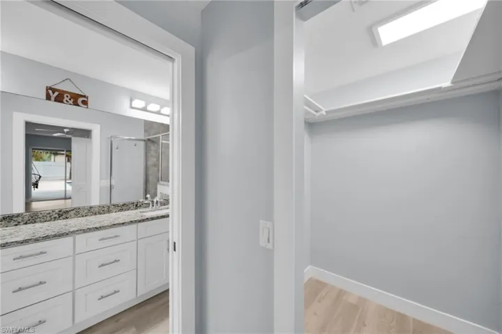 Bathroom featuring vanity, light wood-style flooring, and a stall shower