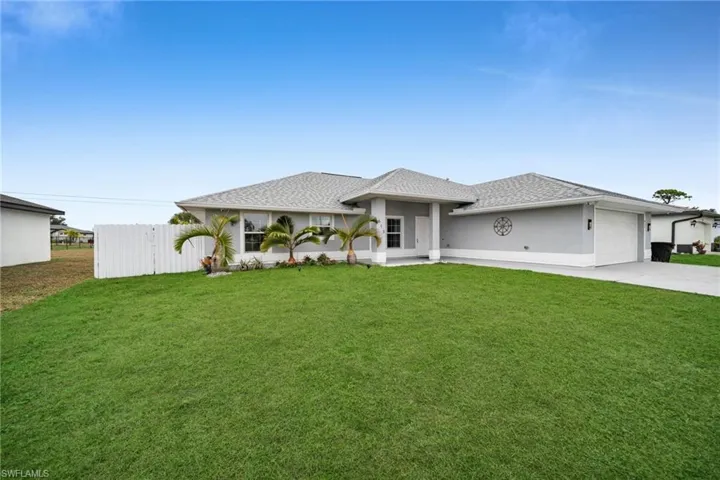 View of front of home featuring concrete driveway, a garage, stucco siding, and a shingled roof