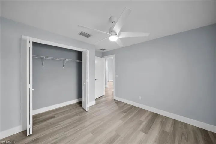 Unfurnished bedroom with a ceiling fan, a closet, and light wood-style floors