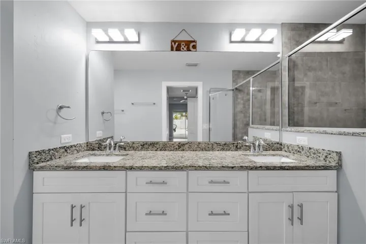 Bathroom featuring double vanity and a stall shower