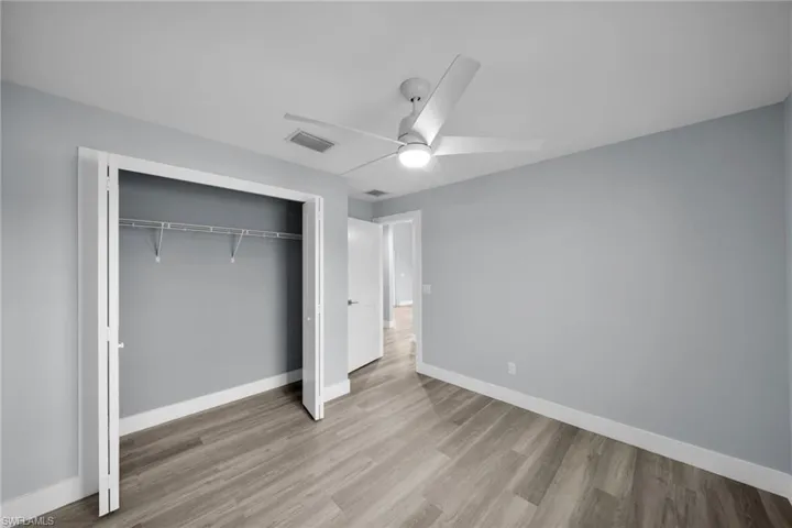 Unfurnished bedroom with a closet, ceiling fan, and light wood-style floors